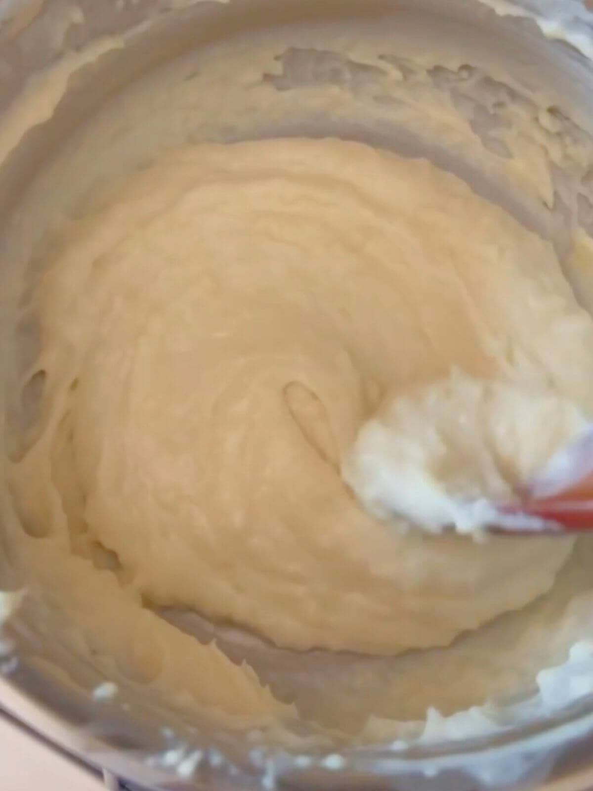 Tangzhong mixture simmering in a saucepan, creating a smooth, thick paste for baking.