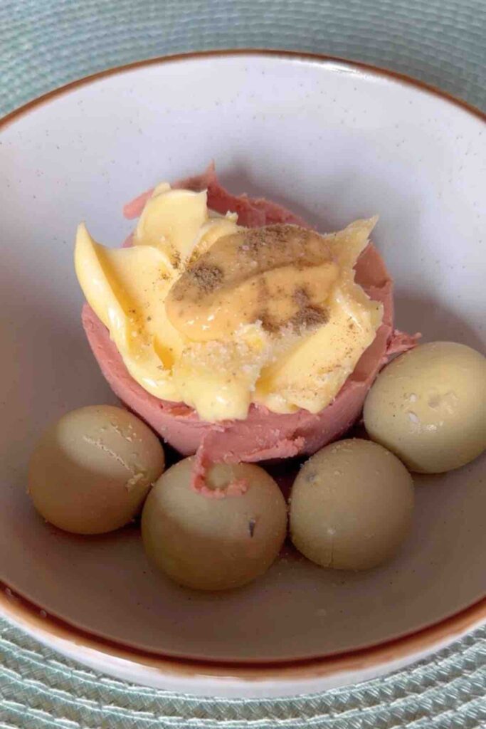 Egg Yolks, chicken pate, butter, mustard, salt and pepper in a bowl ready to be mixed