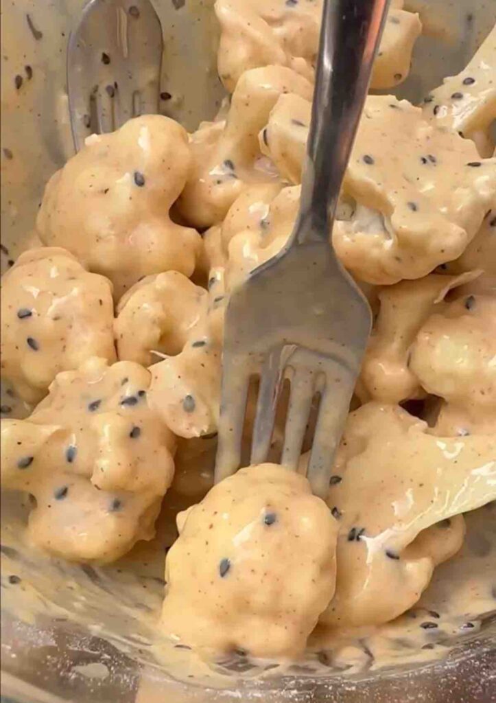 Cauliflower pieces coated in batter, sitting in a bowl.