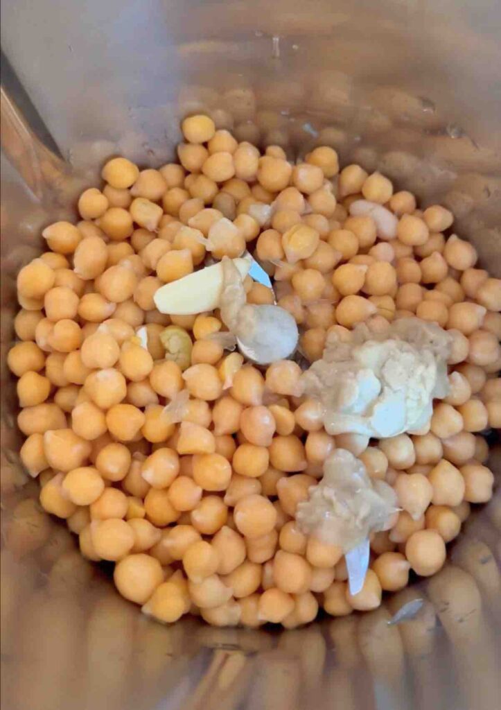 ingredients to make hummus in a mixing bowl