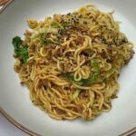 Tantalizing Turkey Mince Noodles on a plate, decorated with black sesame seeds.