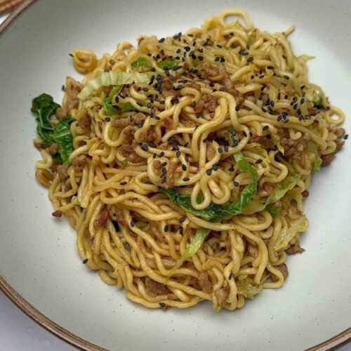 Tantalizing Turkey Mince Noodles on a plate, decorated with black sesame seeds