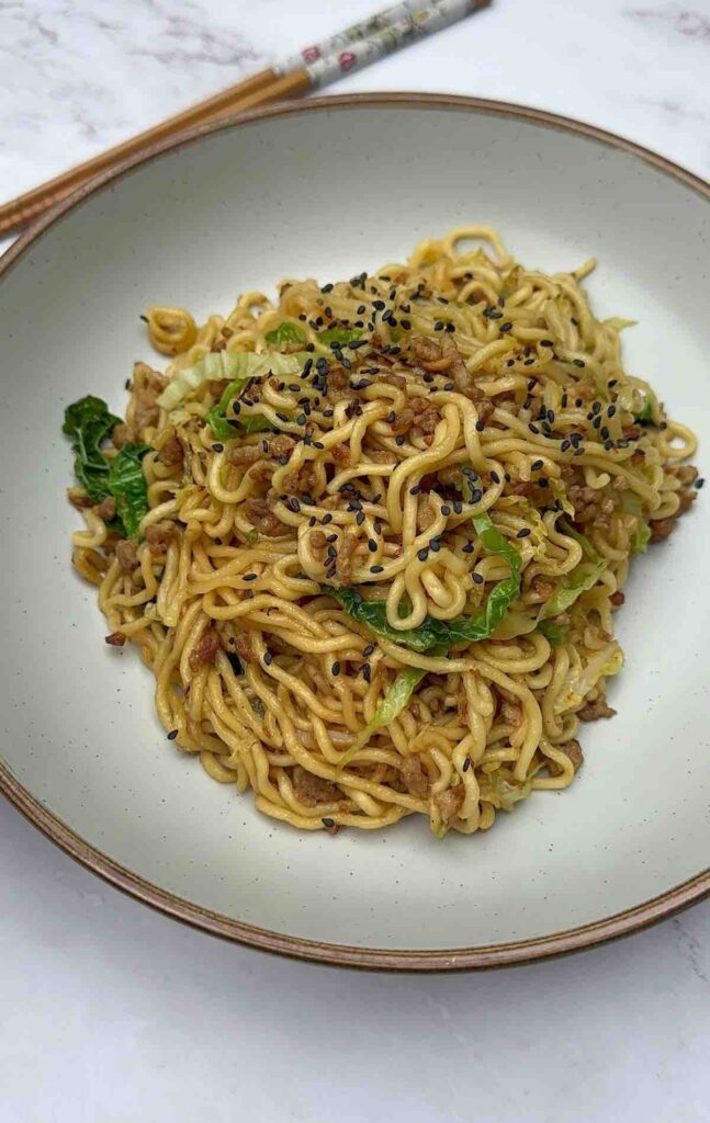 Tantalizing Turkey Mince Noodles on a plate, decorated with black sesame seeds