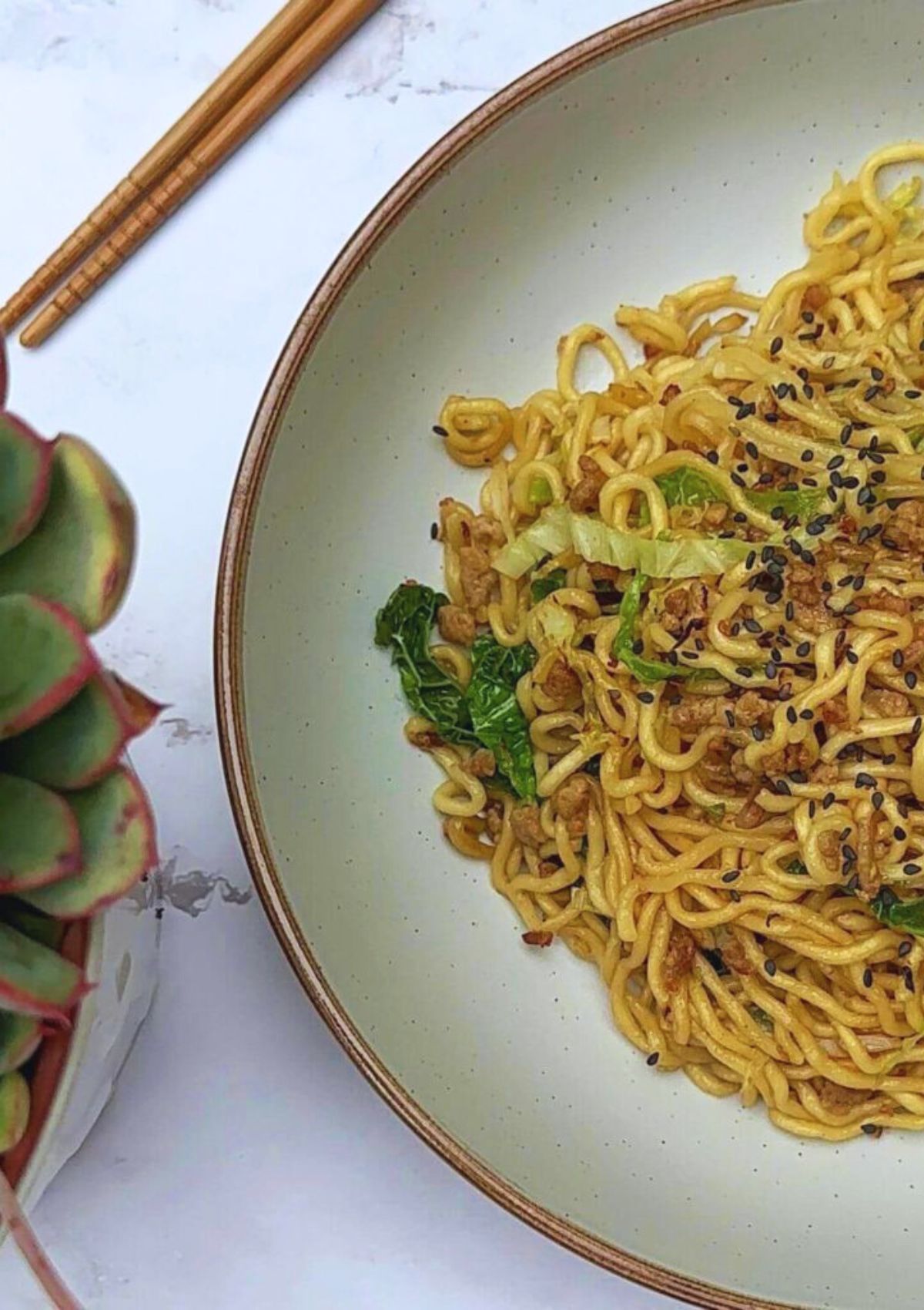 Tantalizing Turkey Mince Noodles on a plate, decorated with black sesame seeds.