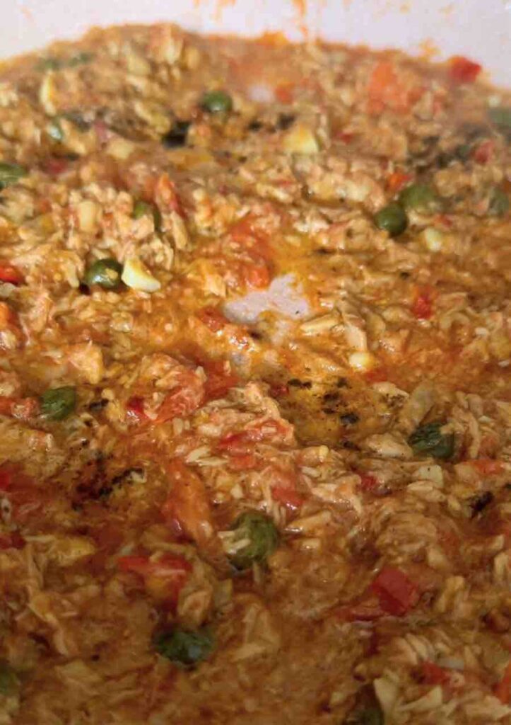 Pan with tuna in olive oil, garlic, chili, and capers, simmering in tomato sauce.