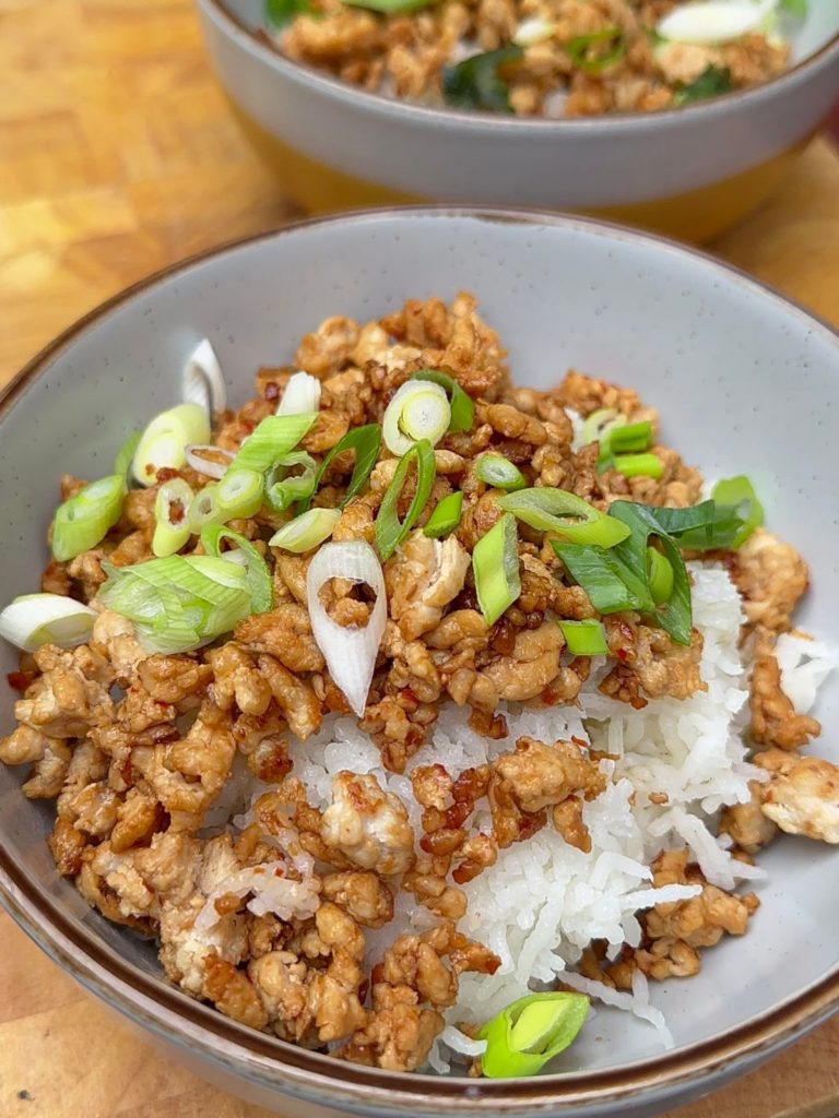 Korean-Style Keema in a bowl over white rice, garnished with fresh green onions. 