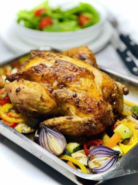 Roast Chicken on a baking pan with baked veggies