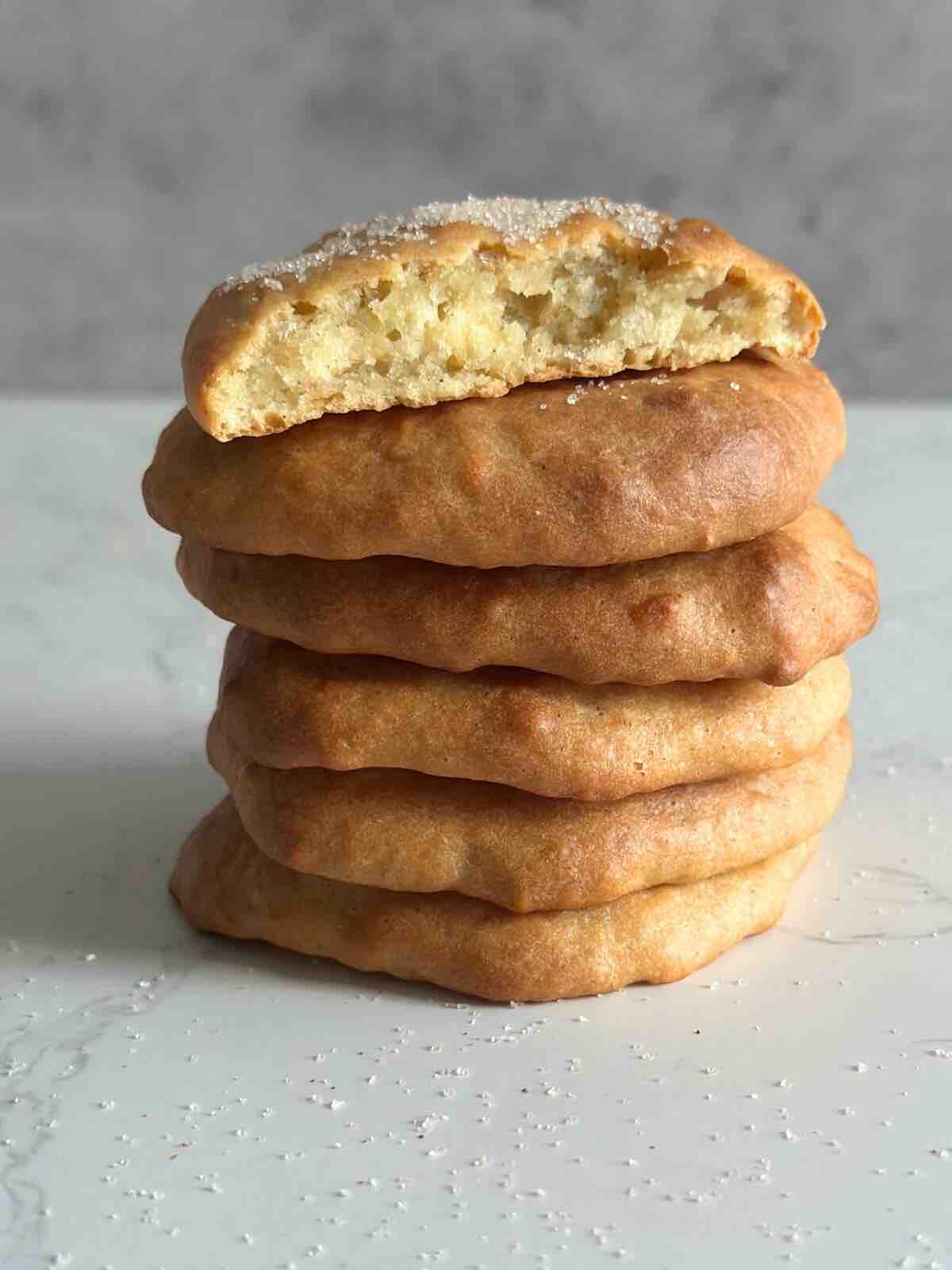 A stack of  baked fritters with the top one halved. 