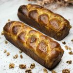 Two baked golden-brown walnut rolls.