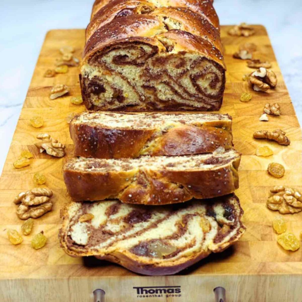 A few slices of walnut roll on a chopping board.