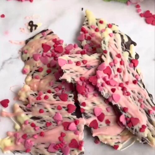 Valentine's chocolate bark made with dark and white chocolate, topped with pink swirls and festive sprinkles.