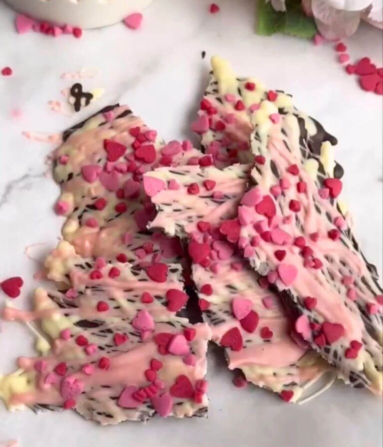 Valentine's chocolate bark made with dark and white chocolate, topped with pink swirls and festive sprinkles.