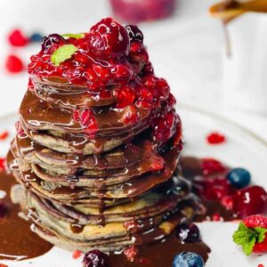 chocolate berry pancakes tower topped with chocolate ganache