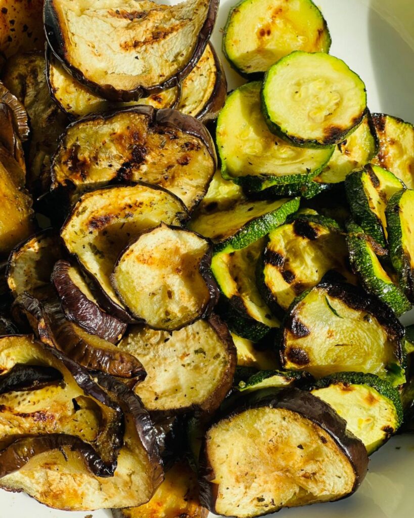 Grilled slices of eggplant and zucchini on a shallow bowl. 