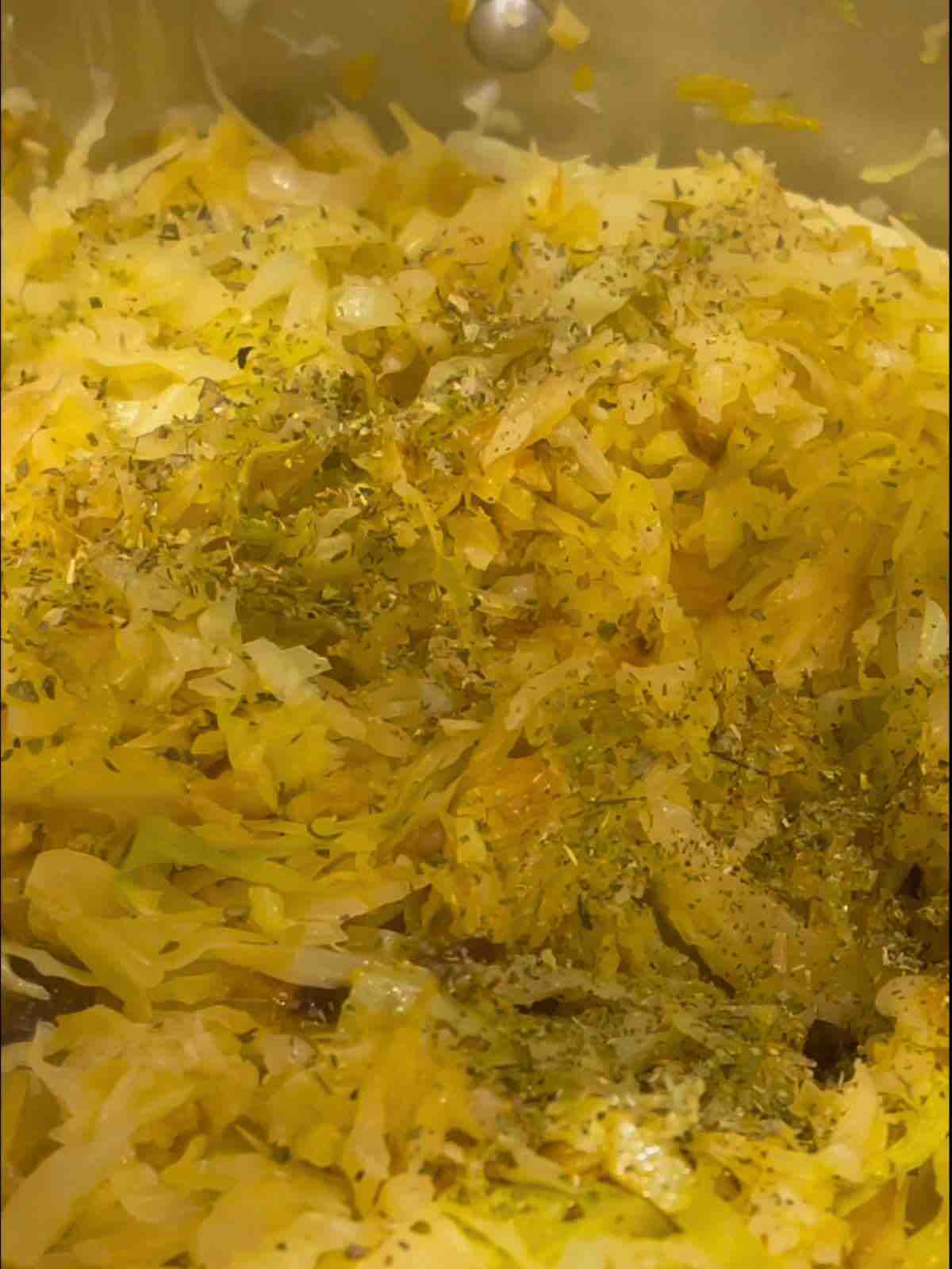 Chopped cabbage cooking in a pan, sautéed until tender and slightly browned.