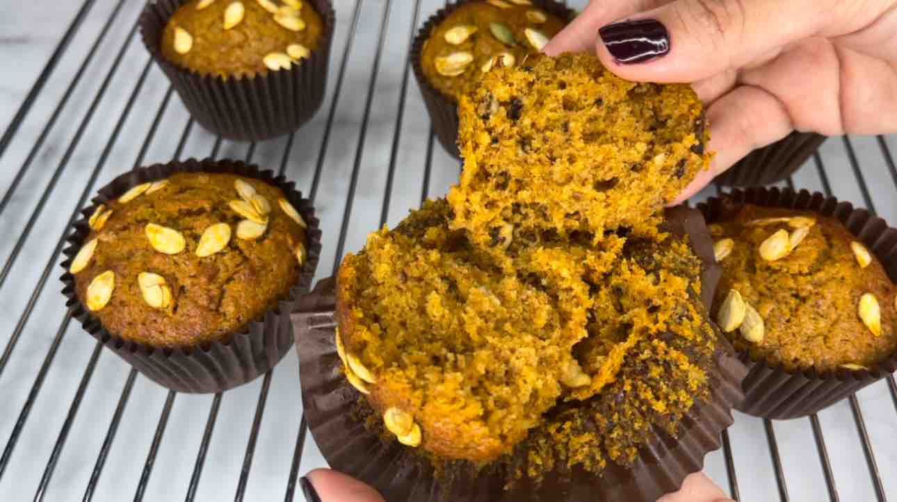 Pumpkin muffin ripped in half, showing the soft and moist inside. 