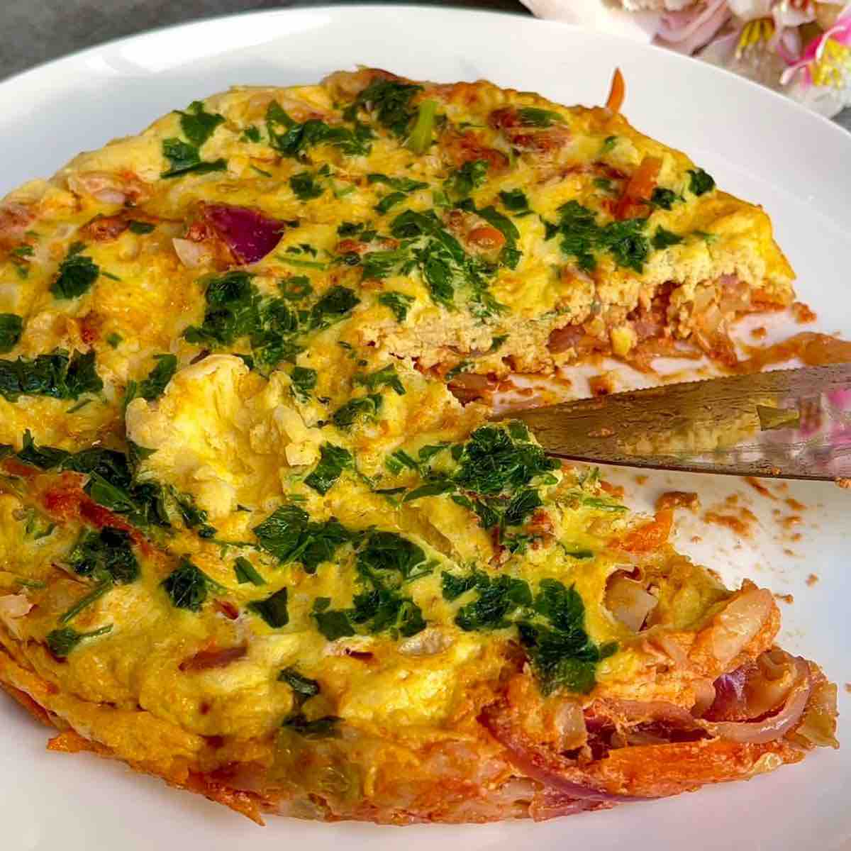 Easy Cabbage Frittata Recipe | Low-Calorie & Veggie-Packed Breakfast Idea on a plate with a slice taken out 