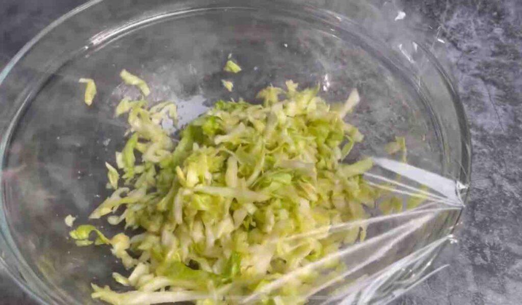 Half a head of cabbage, shredded and placed in a bowl.