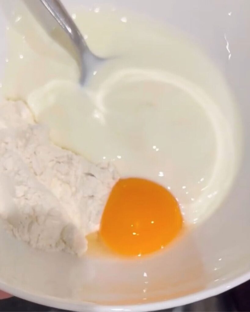 A bowl containing the ingredients for the "Terbive" mix: plain flour, natural yogurt, egg yolk, and lemon juice, ready to be combined.