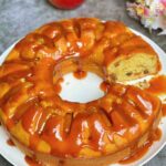 Apple and Raisin Bundt Cake with Caramel Sauce with a slice taken out so you can see the inside of the cake