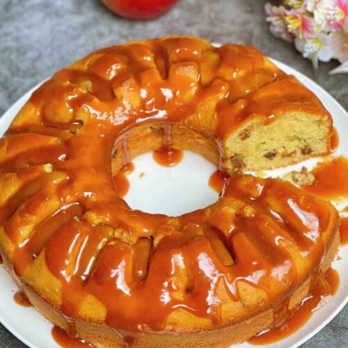 Apple and Raisin Bundt Cake with Caramel Sauce with a slice taken out so you can see the inside of the cake