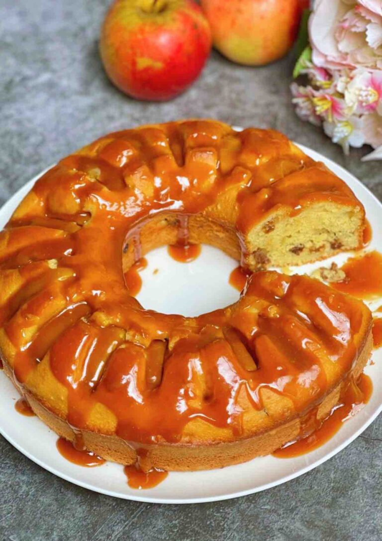 Apple and Raisin Bundt Cake with Caramel Sauce with a slice taken out so you can see the inside of the cake