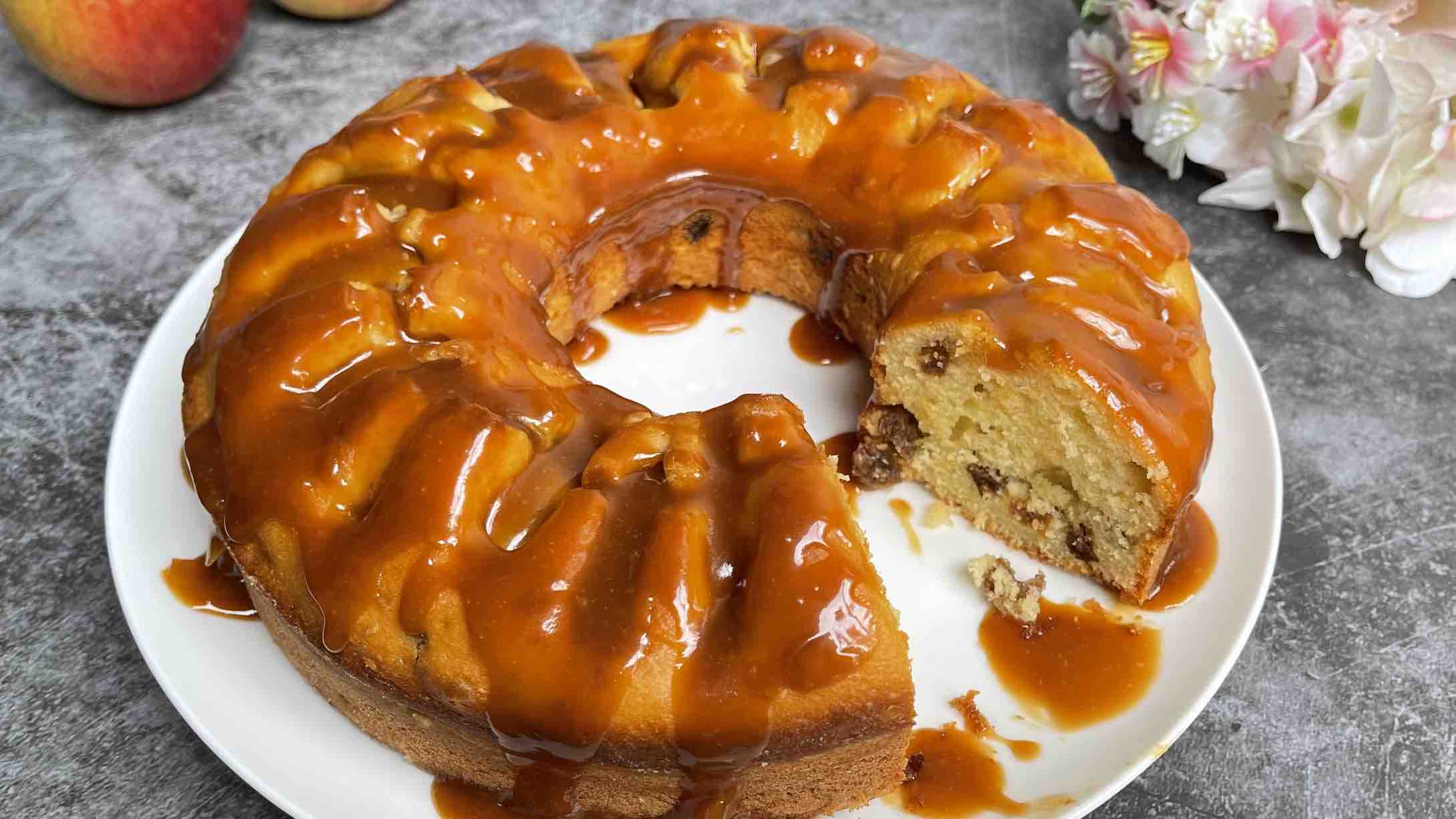 Apple and Raisin Bundt Cake with Caramel Sauce with a slice taken out so you can see the inside of the cake