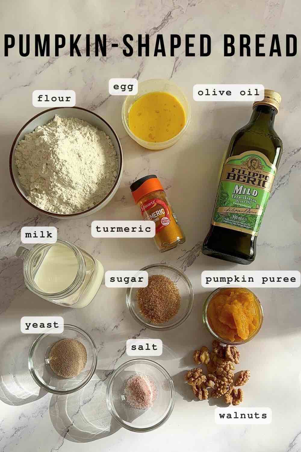 Labeled ingredients for pumpkin-shaped bread: strong white bread flour, fast-action dried yeast, caster sugar, salt, ground turmeric, whole milk, pumpkin purée, olive oil, egg, walnut quarters.