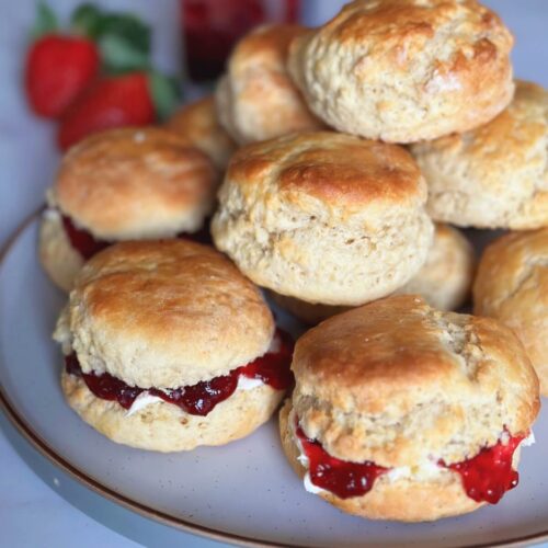 Plate of quick and easy scones with some filled with strawberry jam and others left plain.