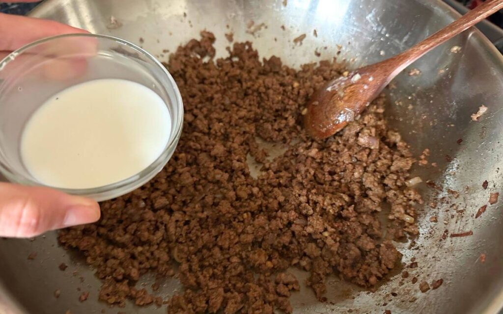 Browned minced beef in a pan, adding dissolved corn starch . 