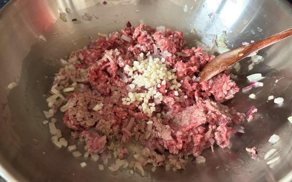 Browning the ground beef in a pan. 