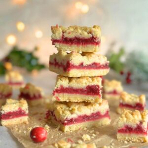 Cranberry crumble bars stacked, showcasing the buttery crust and cranberry filling.