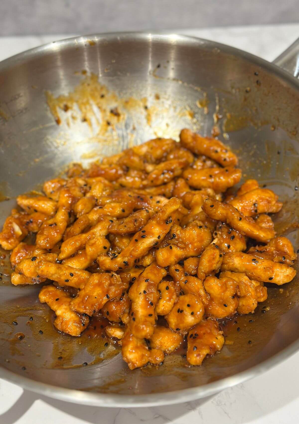 Sesame Chicken in Asian Style in a stainless steel pan 