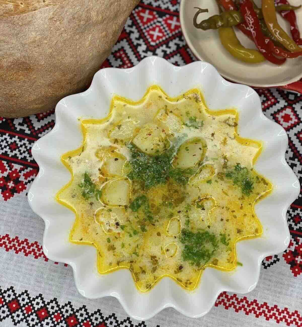 Yoghurt potato soup in a bowl garnished with fresh parsley. 