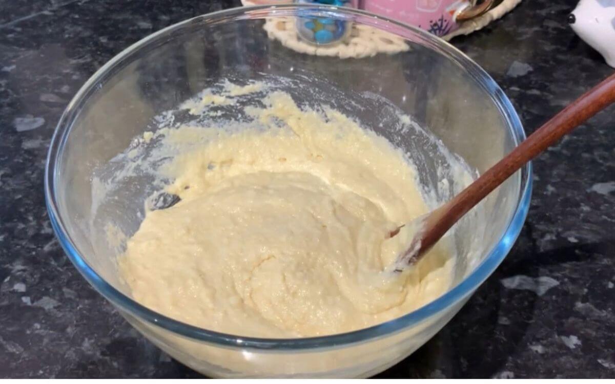 Whisking the batter until smooth and lump-free in a mixing bowl.