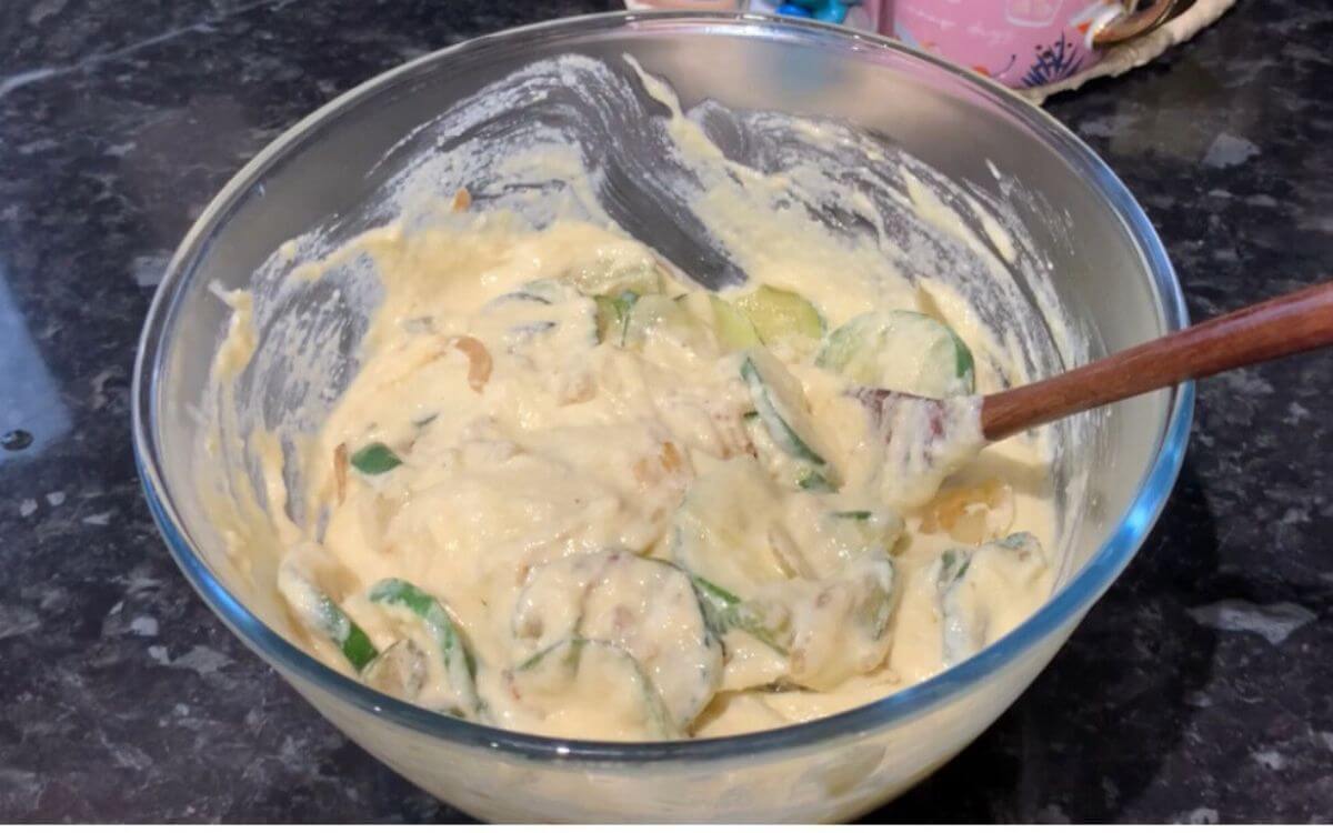 Spreading batter evenly into a thin layer on a baking sheet using a spatula.